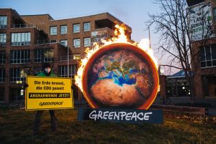 Greenpeace Aktivist:innen protestieren mit brennender Erde vor dem Umweltministerium in Stuttgart gegen die Gemeinsame Agrarpolitik (GAP). Auf dem Banner ist zu lesen: "Die Erde brennt - Die CDU pennt! Agrarwende jetzt!".