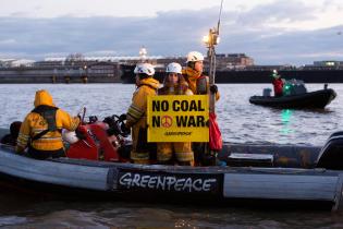 Mit Schlauchbooten und dem Aktionsschiff MS Beluga protestieren Greenpeace-Aktivist:innen im Hamburger Hafen gegen russische Kohleimporte, In zwei Meter hohen Buchstaben schreiben sie  "No Coal No War" auf die Seite des Kohlefrachters "Grant T".
