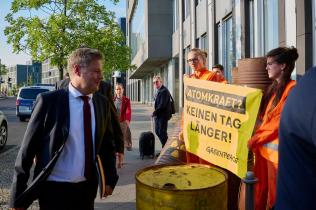 Robert Harbeck passiert Greenpeace-Protest zu Laufzeitverlängerung in Berlin