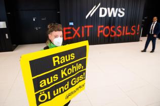 Protest im Foyer der DWS, Frankfurt: Aktivistin hält Banner