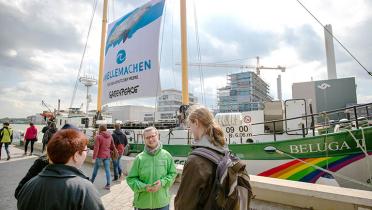 Besucher vor Greenpeace-Schiff Beluga mit Greenpeace-Kampaigner