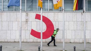 Greenpeace-Aktivisten mit orangenfarbenem CDU-C am Rücken