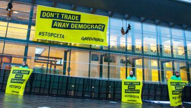 Greenpeace-Aktivisten hängen ein 12 mal 6 Meter großes Banner mit der Aufschrift “Don’t trade away our democracy" an das EU-Ratsgebäude in Luxembourg