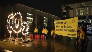 Aktivisten demonstrieren mit brennendem CO2 Zeichen für mehr Klimaschutz vor dem Bundeskanzleramt, Dezember 2011