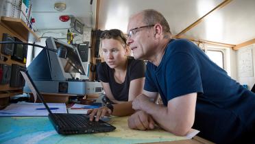 Greenpeace-Mirabeiter Jörg Feddern und Nina Neuscheler an Bord der Beluga betrachten einen Bildschirm