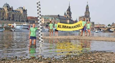 Greenpeace-Aktivisten stehen im ausgetrockneten Flussbett der Elbe bei Dresden