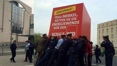 Mit einem großen Würfel fordern Greenpeace-Aktivisten von Bundeskanzlerin Merkel, die Energiewende vor Sigmar Gabriel zu retten, Berlin 01. April 2014 