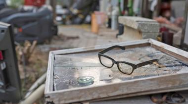 Verlassener Hausrat: Auf einer zerbrochenen Fensterscheibe liegt eine alte Brille.