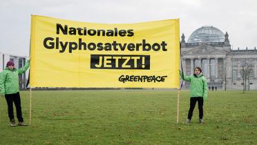 Zwei Greenpeace-Aktivisten halten vor dem Reichstag in Berlin ein Banner mit der Forderung "Nationales Glyphosat-Verbot JETZT!"