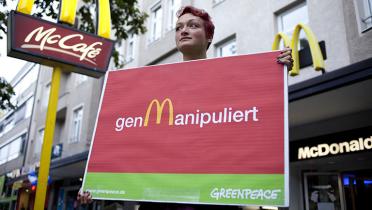 Greenpeace-Aktivistin protestiert vor McDonald's gegen genmanipulierte Futtermittel