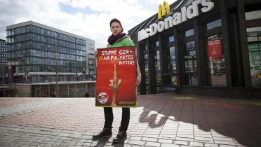 Aktivist mit Banner vor McDonald's