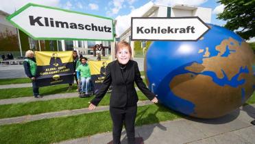Greenpeace-Aktivistin mit Merkel-Maske protestiert vorm Kanzleramt in Berlin für Klimaschutz
