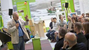 Wolfgang Lohbeck, Leiter der SmILE-Kampagne, diskutiert mit Besuchern im Atrium der Greenpeace-Zentrale in Hamburg. 
