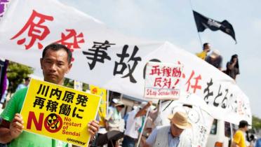 Am AKW Sendai in Japan protestieren Menschen gegen das Wiederanfahren das Reaktors.