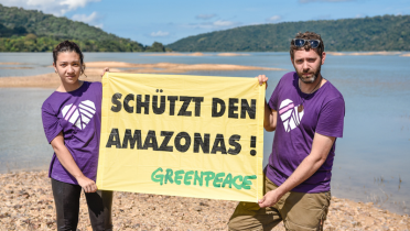 Greenpeace-Aktivisten im Land der Munduruku. Sie halten ein Banner mit der Aufschrift "Schützt den Amazonas".