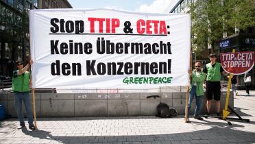 Auf einem Transparent fordern Greenpeace-Ehrenamtliche in Hannover: "Keine Übermacht den Konzernen"