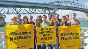 Greenpeace-Aktivisten vor der Auckland Harbour Bridge fordern: "Brücken statt Mauern".