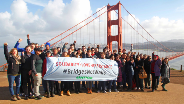 Greenpeace-Aktivisten mit einem Transparent vor der Golden-Gate-Brücke: "#BridgesNotWalls"