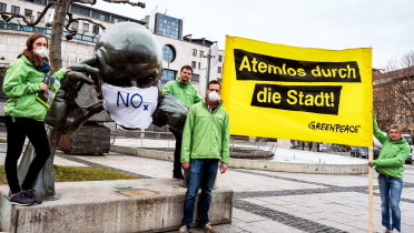 Greenpeace-Aktivisten protestieren an der Denkpartner-Statue in Stuttgart gegen giftige Diesel-Abgase