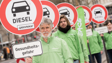 Mit Schilder "Durchfahrt verboten für Diesel" protestieren Greenpeace-Aktivisten in Köln für bessere Luft und gegen Diesel-Abgase