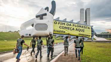 Greenpeace-Aktivisten in Brasilia, Brasilien, protestieren mit einer riesigen aufblasbaren Kettensägen-Attrappe gegen Holzeinschlag im Amazonas-Gebiet.