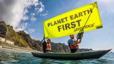 Aktivisten im Kanu, "Planet Earth First"-Banner