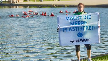 Greenpeace-Aktivistin mit Banner "Macht die Meere plastikfrei"