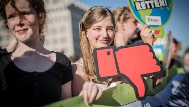 Mädchen mit "Daumen runter"-Schild