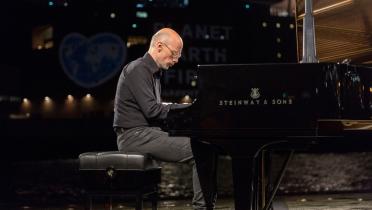 Pianist Michael Abramovich spielt ein Konzert auf der Elbe, "Planet Earth First"-Projektion im Hintergrund