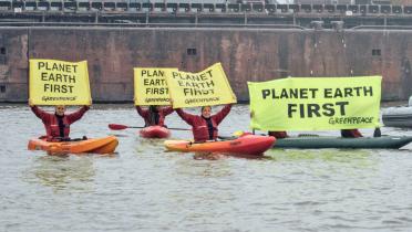 Kajakfahrer im Hamburger Hafen halten Banner mit der Aufschrift "Planet Earth First".