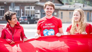 Drei Aktivisten auf der "Tour en rouge" halten ein rotes Band