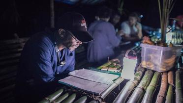 Nachtszene Camp im Kongo, Mann mit Unterlagen