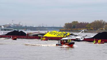 Kohleschiff mit Anti-Kohle-Banner auf dem Rhein