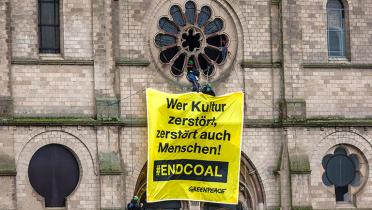 Banner über Kirchenpforte: "Wer Kultur zerstört, zerstört auch Menschen!"