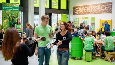 Greenpeace-Sprecherin Viola Wohlgemuth mit Mikrophon im Greenpeace-Atrium