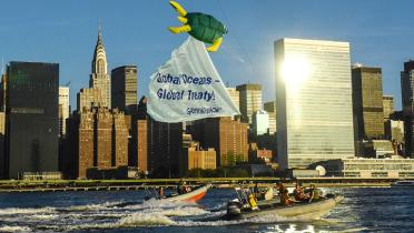 Schlauchboot mit Banner "Global Oceans, Global Treaty" vor der Manhattan-Skyline