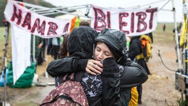 Zwei Demonstrantinnen vor "Hambi bleibt"-Banner