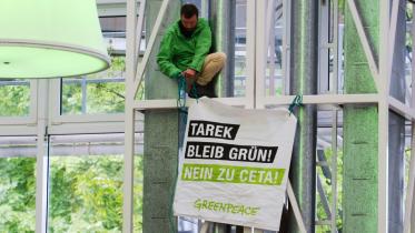 Aktivist mit Banner "Tarek, bleib grün!"