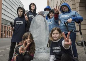Sieben Kinder mit einem Pinguin aus Eis