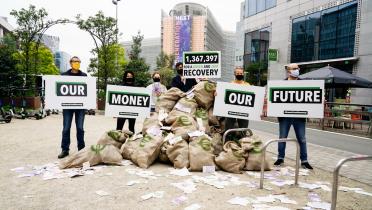 Aktive in Brüssel mit Handbannern "Our Money, Our Future"