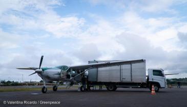 Das Greenpeace Flugzeug und ein LKW mit Hilfsgütern