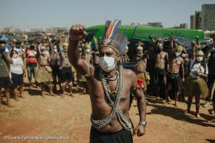 Ein indigener Mann streckt die Faust in die Höhe