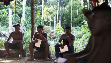 Indigene sitzen zusammen in einem Zelt, und planen den Schutz ihres Reservates.