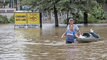 Nach Hurricane Harvey und den folgenden heftigen Regenfällen zieht ein Ehepaar ein Kajak durch den überfluteten Ort Katy in Texas, USA.