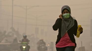 Die Einwohner der Provinz Riau tragen wegen des Rauches in der Luft Atemschutzmasken 06/23/2013
