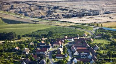Im Hintergrund des Dorfes Gießen frisst sich der Tagebau in die Felder.