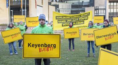 Greenpeace-Aktivisten halten Ortsschilder mit "Keyenberg bleibt"