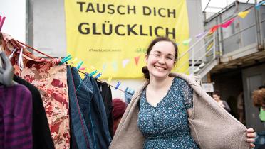Junge Frau präsentiert fröhlich ihre ertauschte Strickjacke