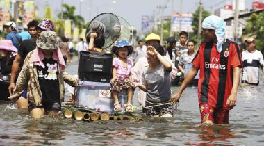 Flut in Thailand: Menschen retten ein Kind und ihr Hab und Gut mit einem Floß.