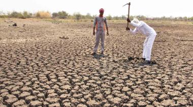 Bauern in Indien bearbeiten vertrocknetes Feld.